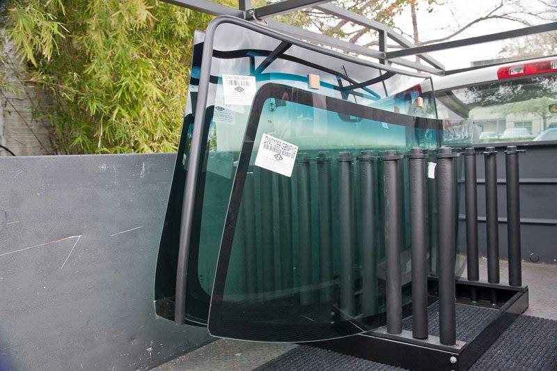 Replacement windshields secured in a transport rack.